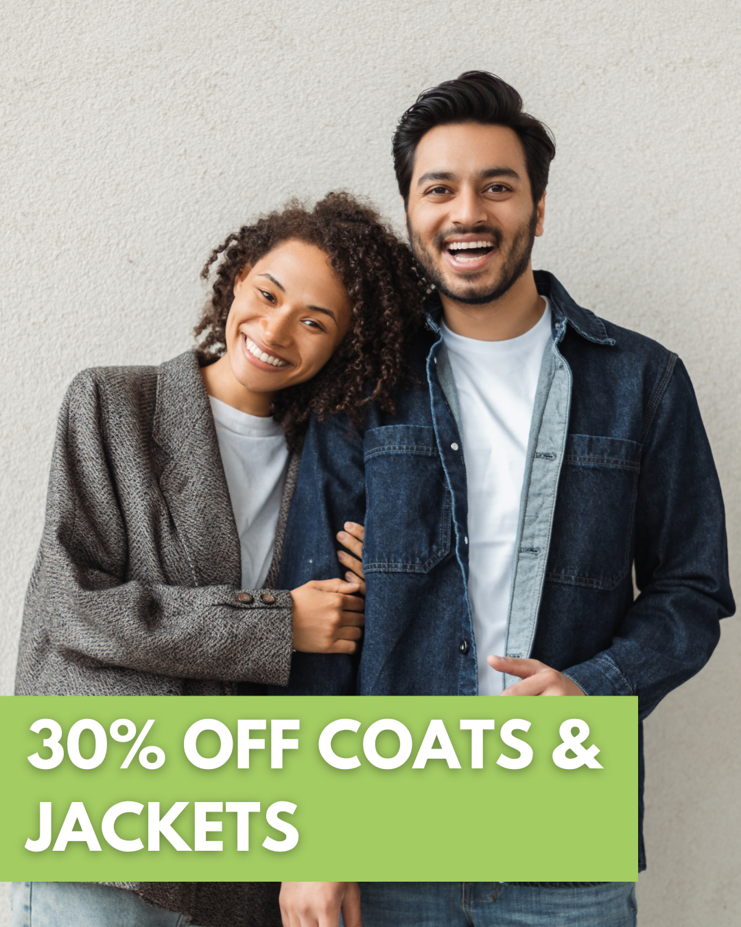 Two black suits with ties are displayed on mannequins. A green label reads 