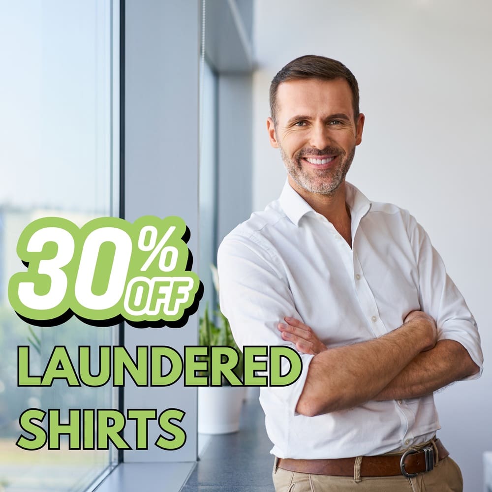 Smiling man in a white shirt stands by a window. Text on image reads "30% off laundered shirts.