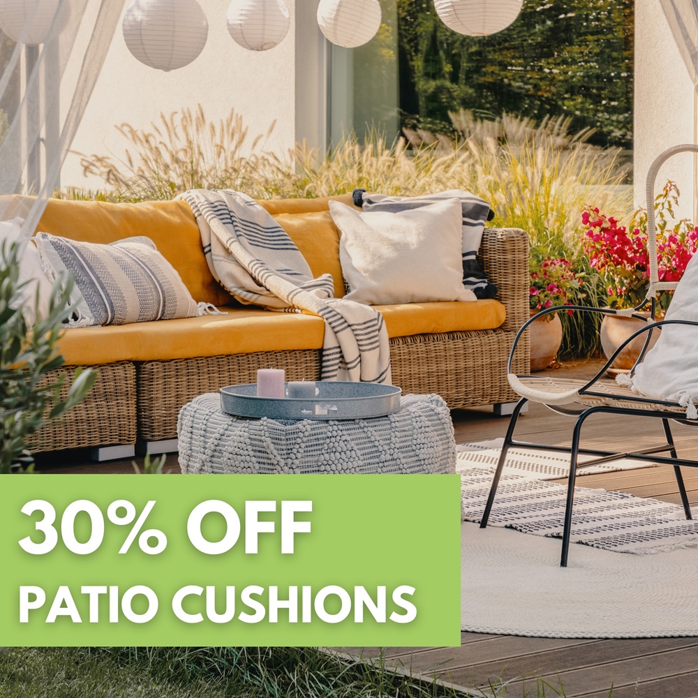 Outdoor patio with wicker sofa, yellow cushions, pillows, a patterned ottoman, chair, and decorative lanterns. Text overlay reads “30% OFF PATIO CUSHIONS.”.